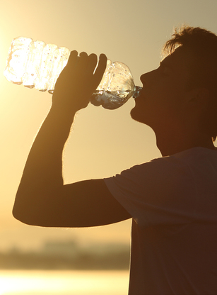 Silhouette Of A Man Drinking A Bottle Of Water